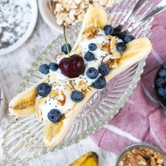 Healthy banana split topped with yogurt and cherries