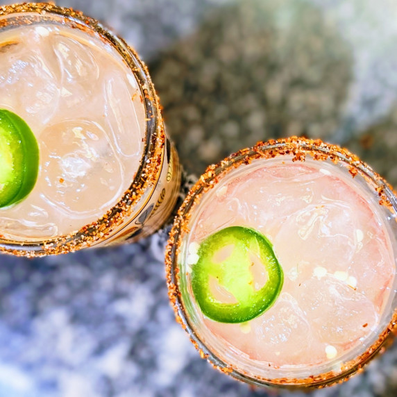 jalapeno grapefruit mezcalitas in glasses with a slice of jalapeno floating in the drink