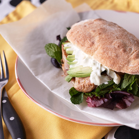 Jerk Chicken Sandwich with avocado and mesclun on a Turkish bun, dressed with sour cream sauce 