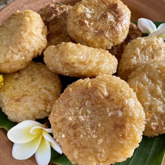 Grilled sticky rice with egg (khao jee) in hamburger shapes with a white flower.
