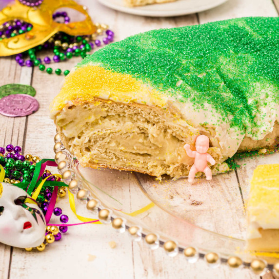 a king cake that has been sliced and a baby showing