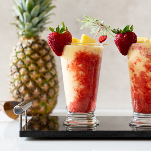 Pina Colada and Strawberry Puree in a Tall Glass with a Pineapple and Sunglasses