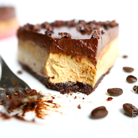 Slice of high protein keto mocha coffee cheesecake topped with a thick layer of chocolate ganache.