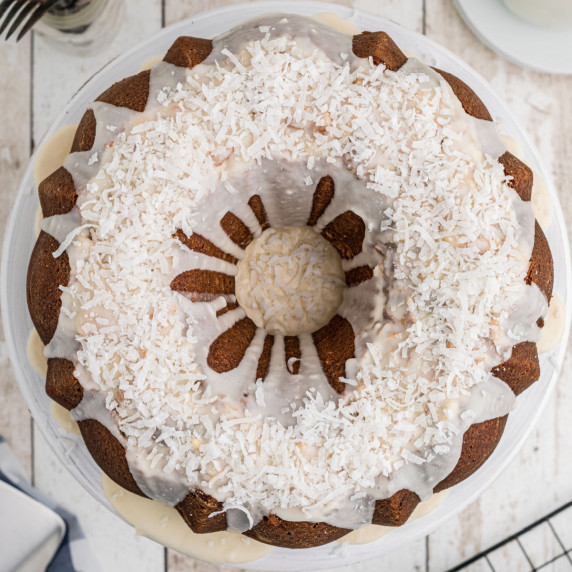 a round bundt cake with a glaze topped with sprinklings of coconut