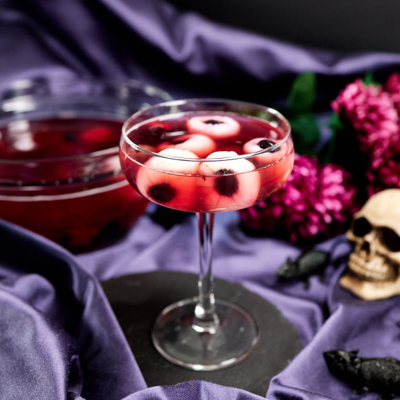 Halloween red punch with eyeballs made of lychee fruit in cocktail glass.