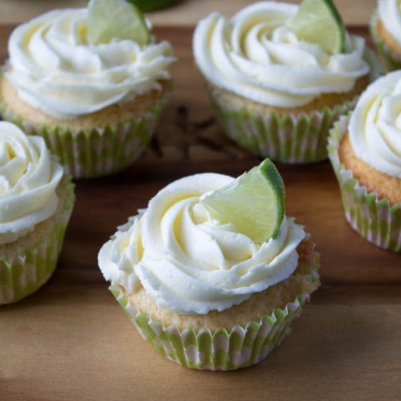 Margarita Cupcakes with a lime wedge on a wooden board