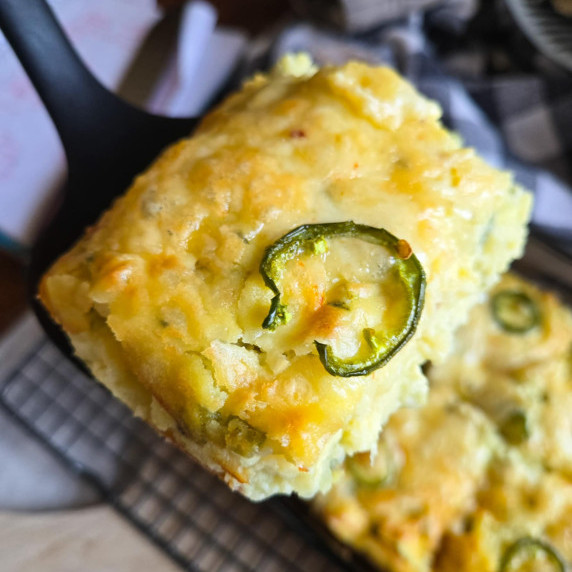 A slab of mashed potato casserole with a green jalapeno slice on top