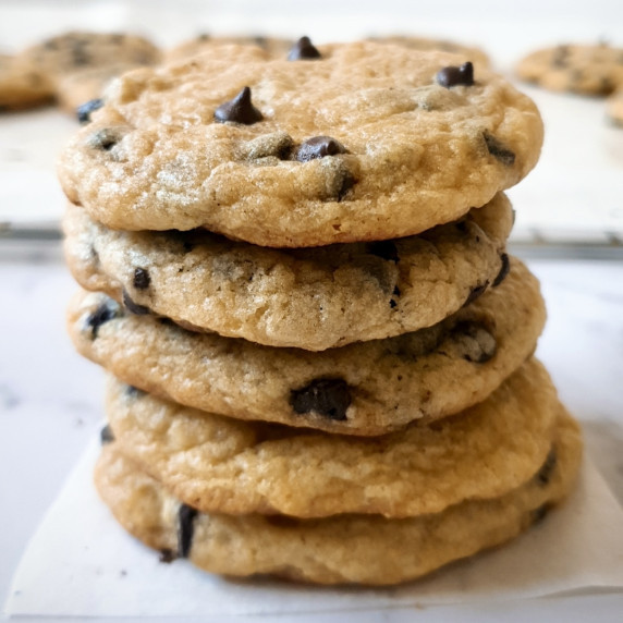 Five stacked McDonald's Chocolate Chip Cookies on a small piece of parchment paper.