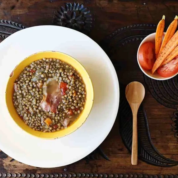 Mexican Lentil Soup in a yellow bowl on top of white plate