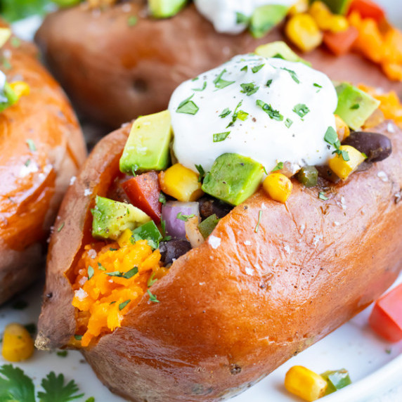 Mexican Stuffed Sweet Potatoes RECIPE garnished with sour cream and fillings.