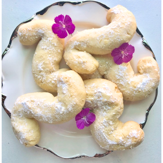 Plate of Middle Eastern butter cookies (Ghorayeba) dusted with powdered sugar.