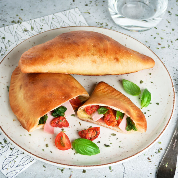 These ini calzones are stuffed with mozzarella cheese, ham, sundried tomatoes and fresh basil! 