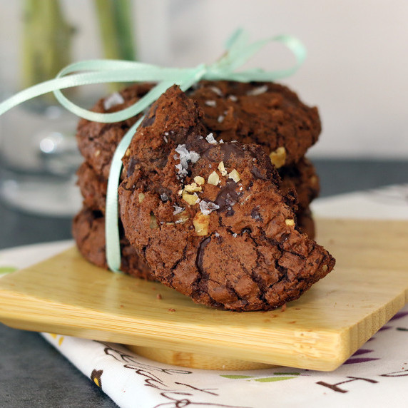 A stack of mudslide cookies tied with a green bow on a square wooden plate