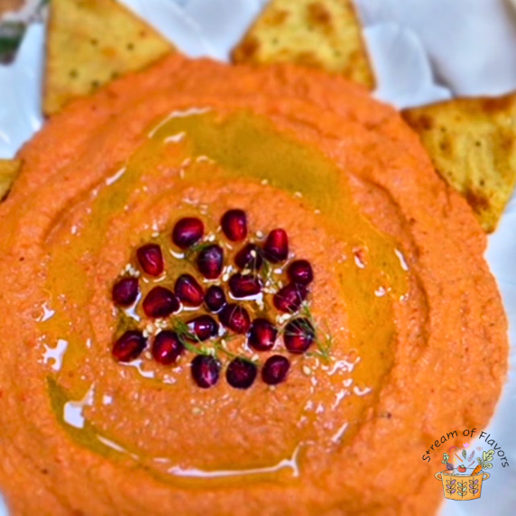 Muhammara with pomegranate seeds, walnuts, sesame seeds, and olive oil with crackers