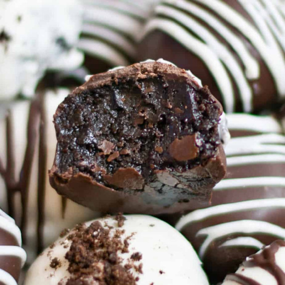 Close up on an Oreo ball with a gooey bite missing on top of other Oreo balls.