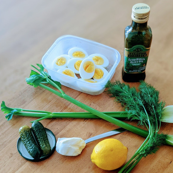 ingredients to make no mayo egg salad arranged on a wooden countertop
