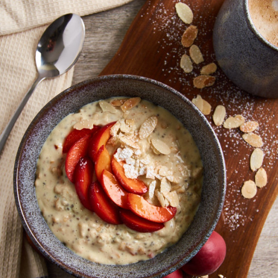 A bowl of creamy oats with fresh apricots and almonds with added protein.