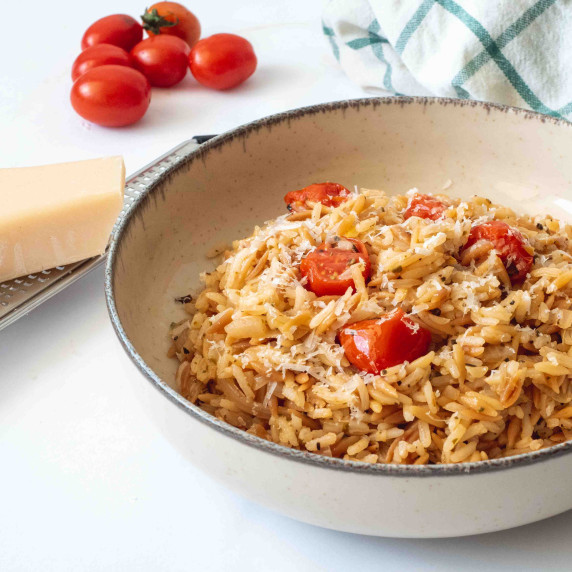 Orzo rice and tasty roast cherry tomatoes arranged in a white bowl