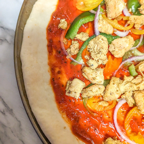 Pizza dough with pizza sauce chicken and vegetables 