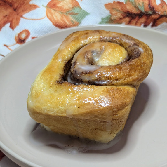 A pumpkin spice bun on a plate.