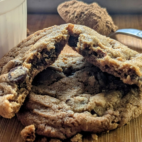 Gingerbread chocolate chip cookies, one is broken in half lying on top of the other one. 