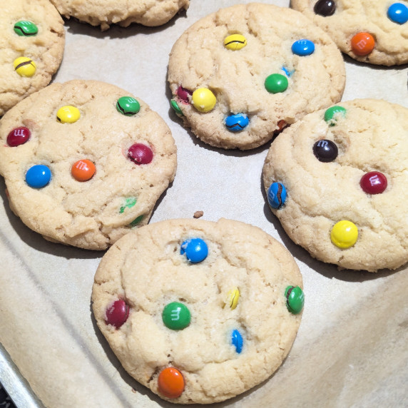 M&M Cookies on a parchment lines pan.