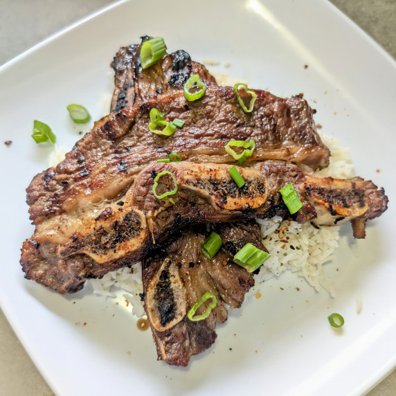 Two Korean-Style Short ribs on a plate of rice. 