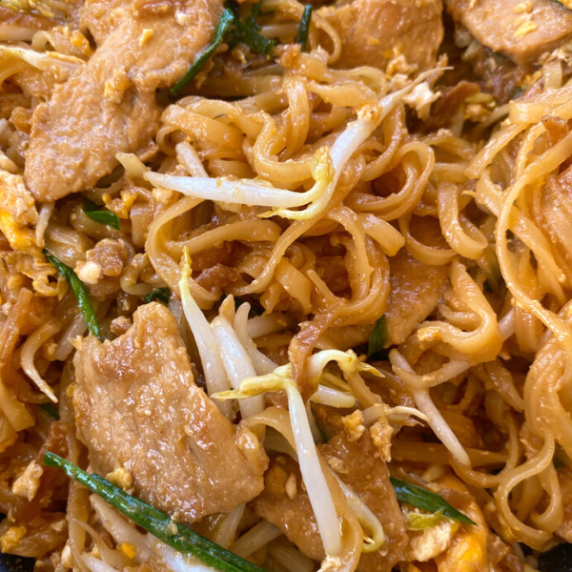 Pad Thai noodles with pork meat, bean sprouts, and a few strips of thinly cut spring onions.
