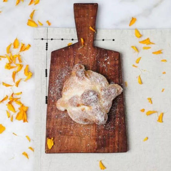pan de muerto - bread of the dead on the chopping board. 