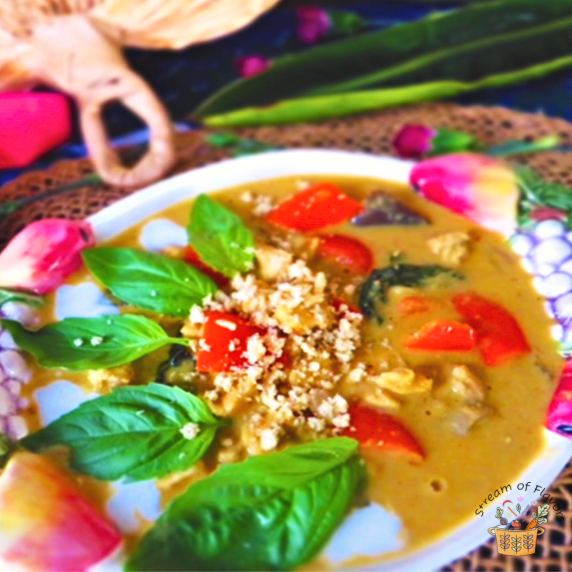 Panang Chicken Curry with peanuts and coconut milk topped with Thai basil leaves and bell peppers