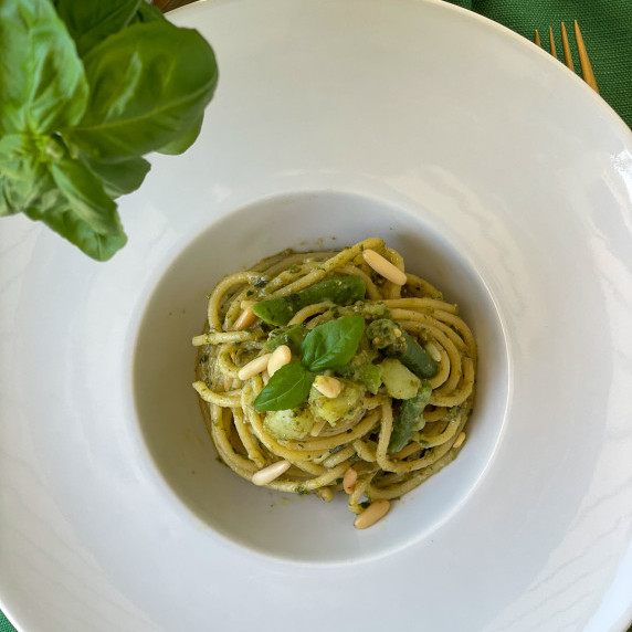 Swirl of Pasta with Pesto on a white plate.
