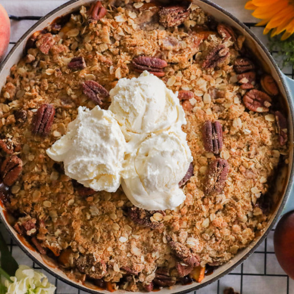 homemade bourbon peach crisp with cinnamon and vanilla ice cream