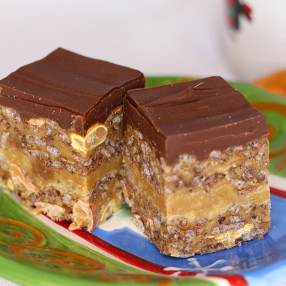 Peanut butter cup Rice Krispie treats on a holiday plate against a white background.