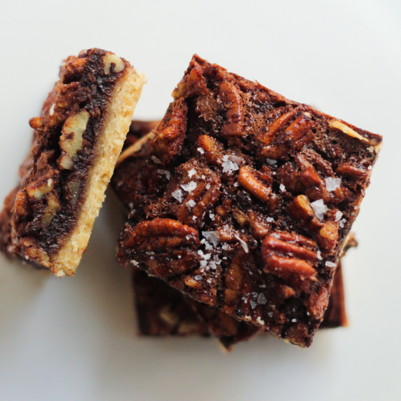 Pecan pie shortbread bars stacked on top of each other on a white plate fall dessert recipes.