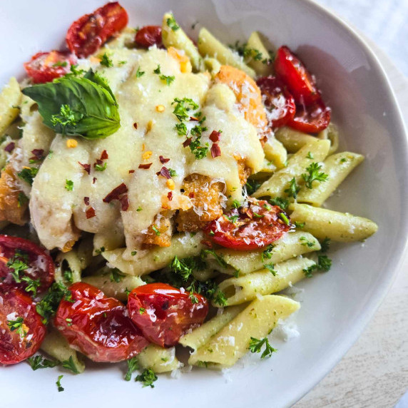 Gorgeous, green penne topped with cheesy chik'n, green herbs, and bright red tomatoes