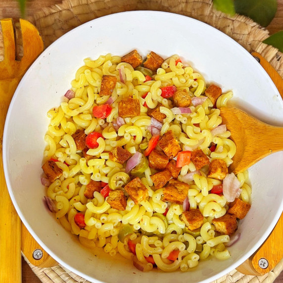 Chicken macaroni salad arranged in a white bowl on burlap sack mat