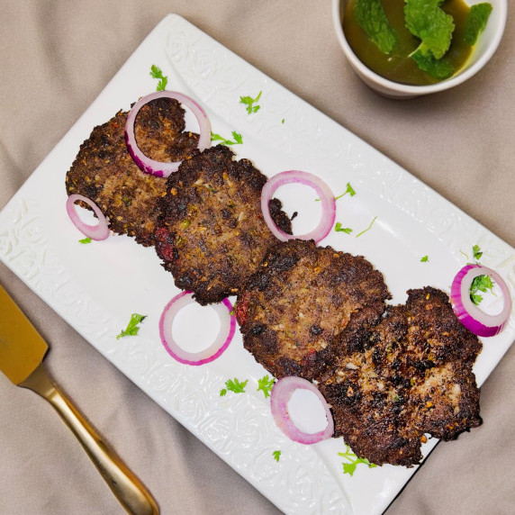 Chapli kabab placed in a white dish on a neutral linen