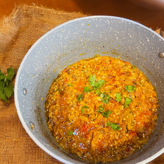 Baingan bharta arranged in pot placed on burlapSack 