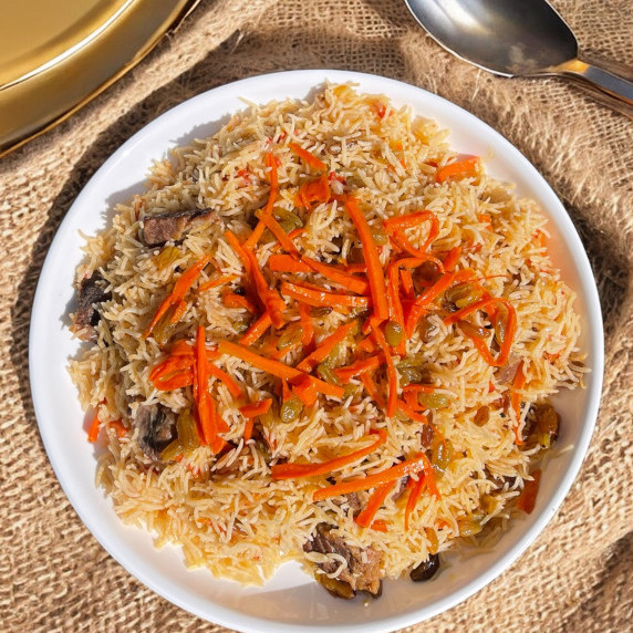 Kabuli Pulao arranged in white plate placed on jute 