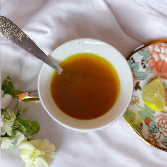 Lekon ginger tea arranged in floral cup on white linen 