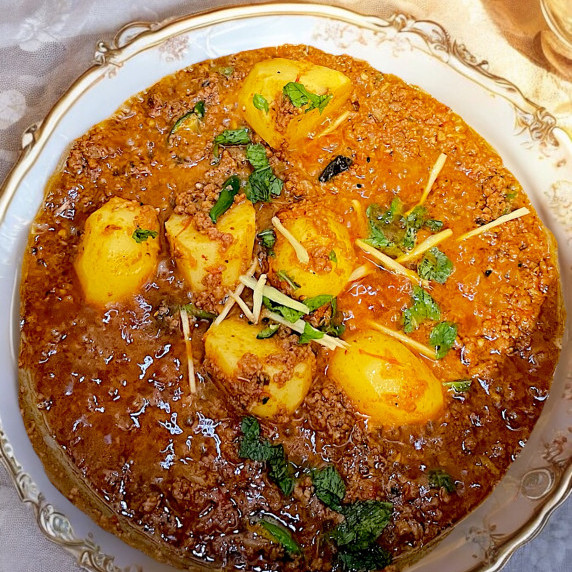 Aloo keema arranged in white bowl on neutral linen