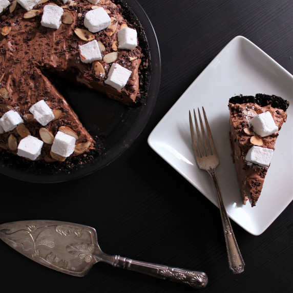 Rocky Road Pie with a slice cut out on a white square plate. 