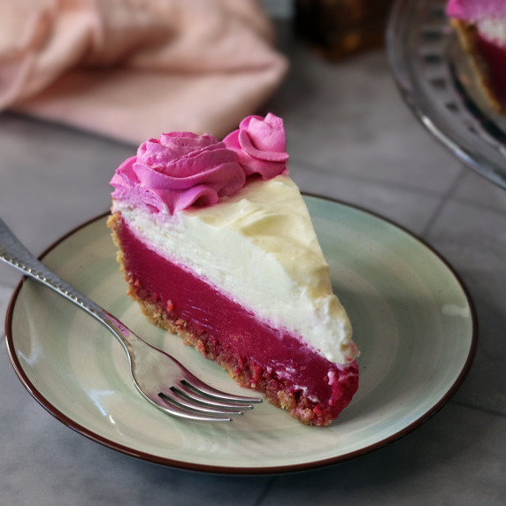 A slice of prickly pear lemonade pie on a white plate with a fork
