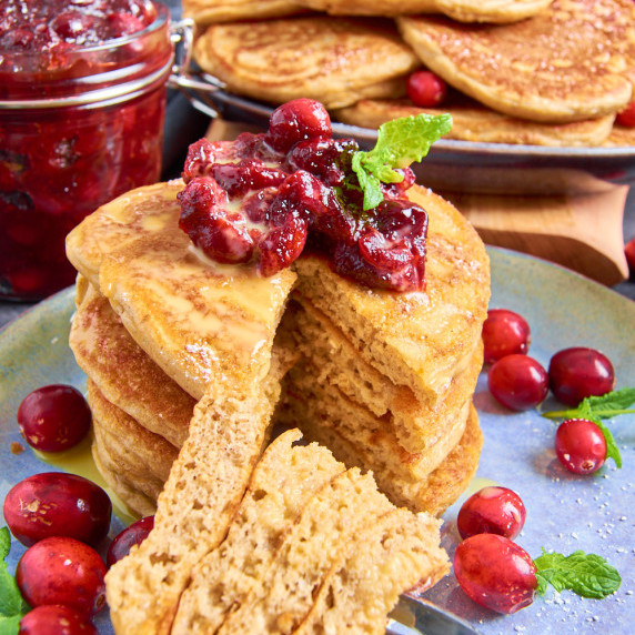 A stack of Sourdough Buttermilk Protein Pancakes topped with cranberry sauce and Advocaat