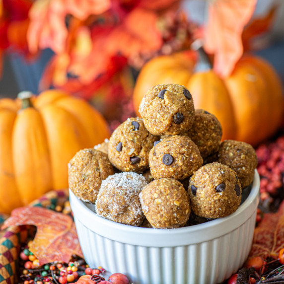 Pumpkin spice energy bites stacked high in a ramekin dish 