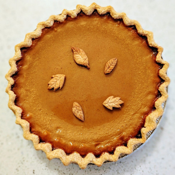 homemade pumpkin pie with buttery pie crust on a counter