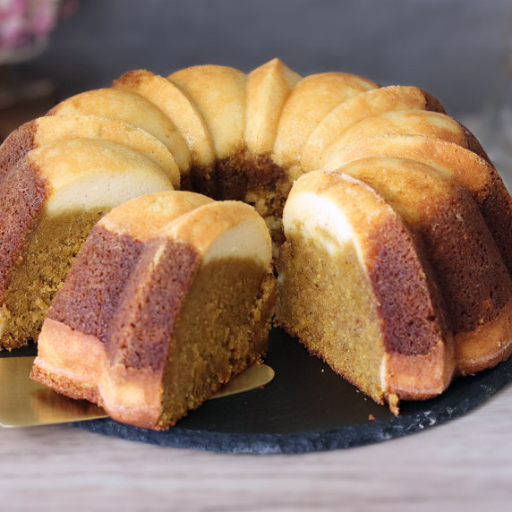 Pumpkin Ricotta Breakfast Bundt on a slate platter with a slice removed and about to be served.