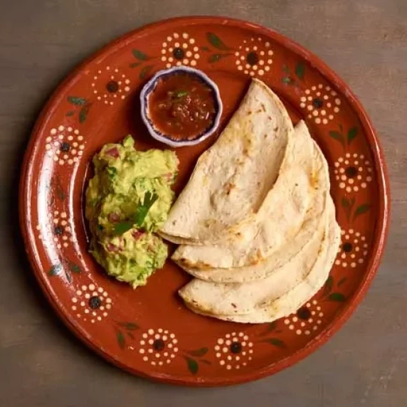 Quesadillas and Sincronizadas with guacamole served in a plate