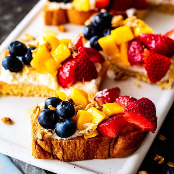 Slices of ricotta toast on a white serving board.