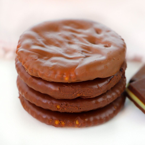 A stack of 4 chocolate covered Ritz crackers with an Andes Mint next to them